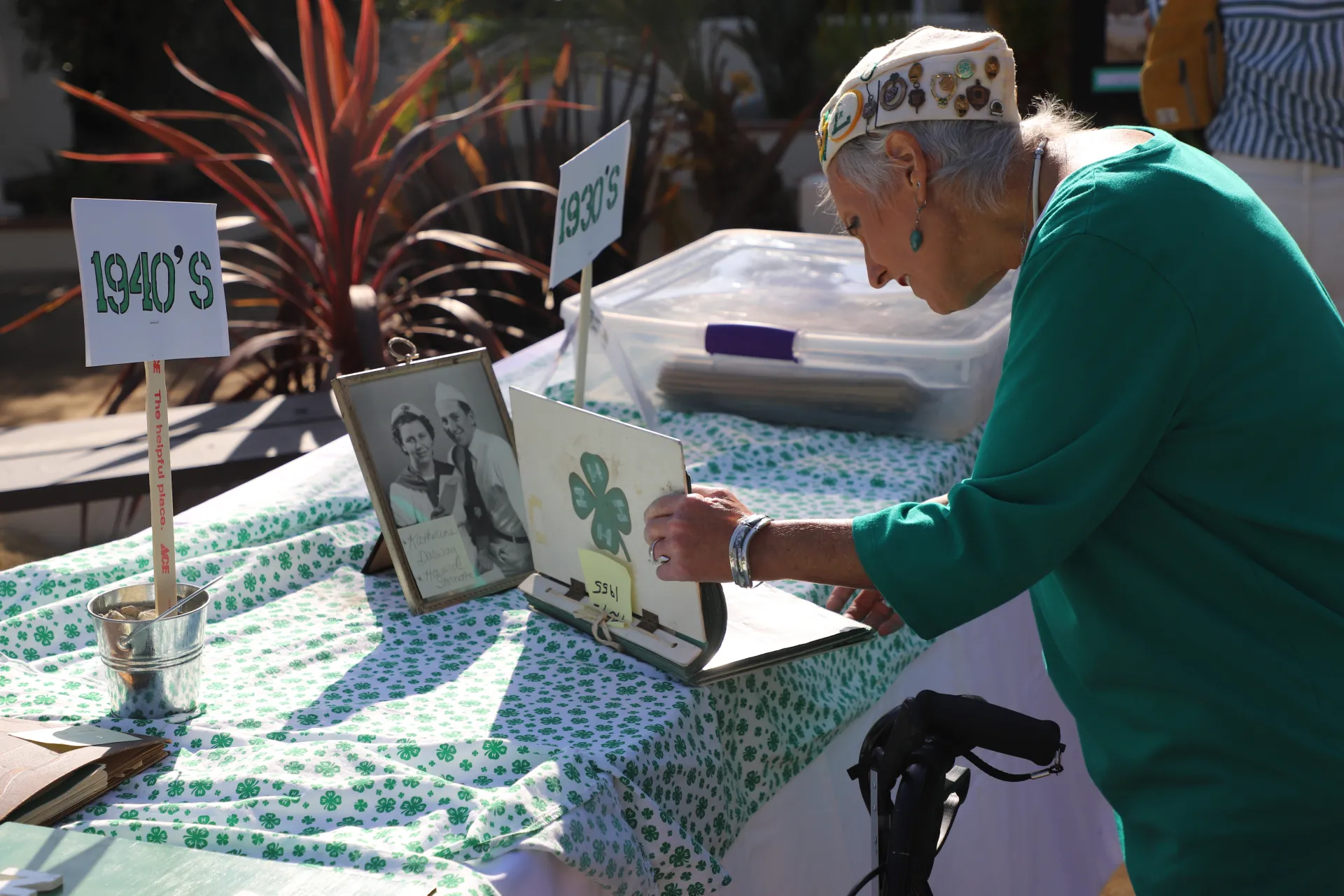A older women with a walker looks at 4-H reporter books.