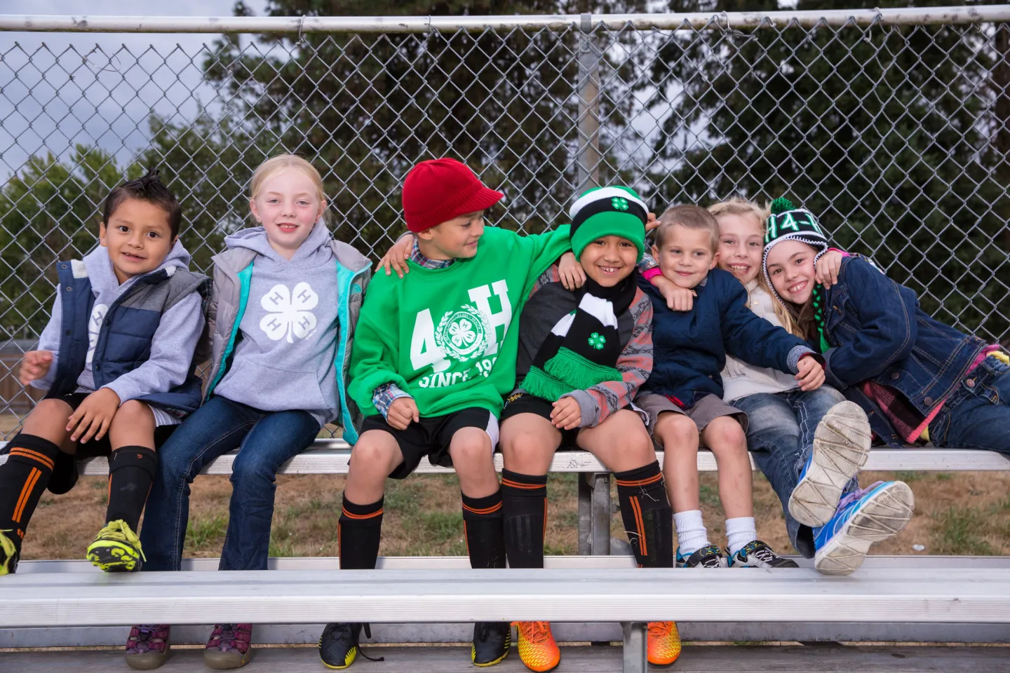 7 young youth sitting together on a bench