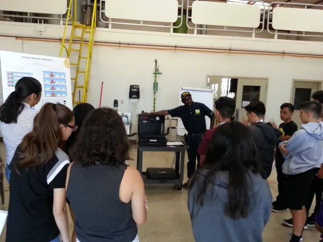 Dr. Peter Larbi demonstrating atomization, the process of breaking up bulk liquid to produce spray.