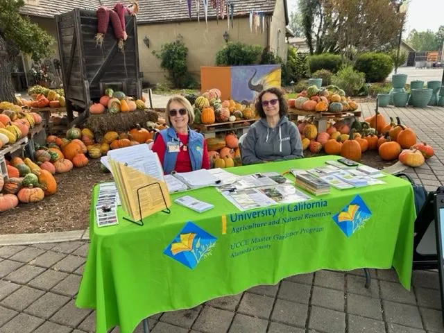 Master Gardeners at their table at a farmers' market. Photo credit: S. Wentz
