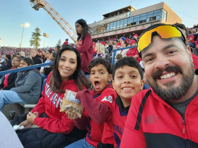 Leonel Jimenez with his wife and two sons at a Fresno State football game