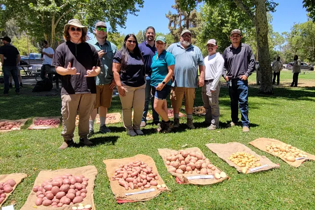 Leonel Jimenez (center) smiles with the potato variety trial team