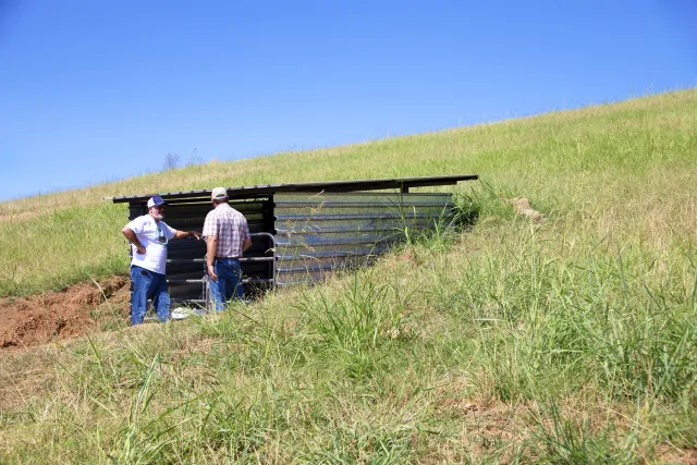 Toby O'Geen talks with a staff member by the trench dug into a hillside at Sierra Foothill REC