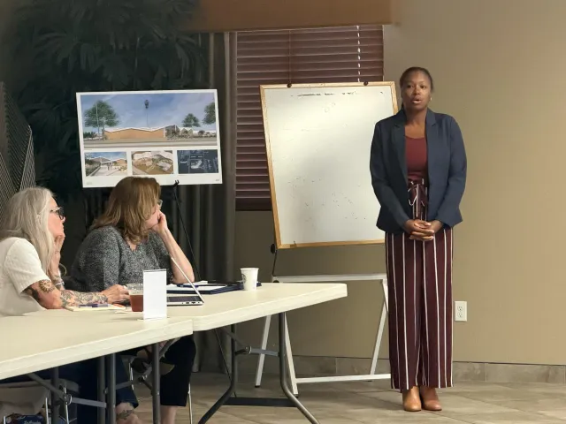 Chandra Richards stands in front of a white board giving a presentation