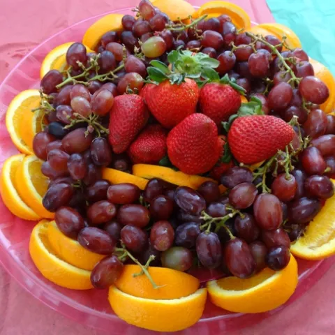 Plate of cut fruit and grapes