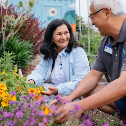 Two people gardening in a community green space