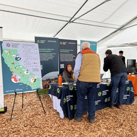 Lucie chats with a man visiting the California AgTech Alliance table