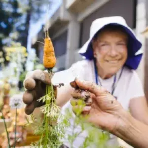 Older women point to a Carrot she is holding